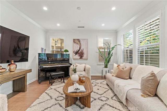 living room featuring recessed lighting, wood finished floors, baseboards, visible vents, and crown molding