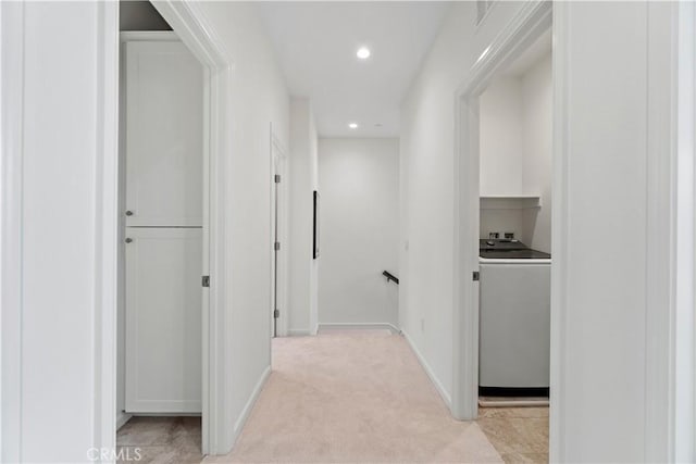 corridor featuring recessed lighting, light colored carpet, washer / dryer, an upstairs landing, and baseboards
