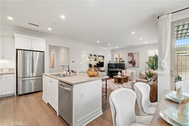 kitchen featuring white cabinetry, a sink, visible vents, stainless steel appliances, and light countertops