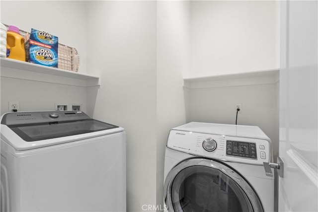 clothes washing area with washing machine and clothes dryer and laundry area