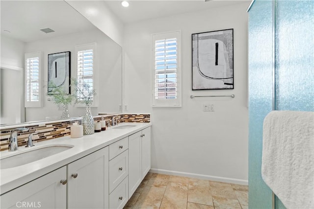 bathroom with a sink, backsplash, and visible vents