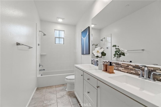 bathroom with toilet, a sink, decorative backsplash, and baseboards