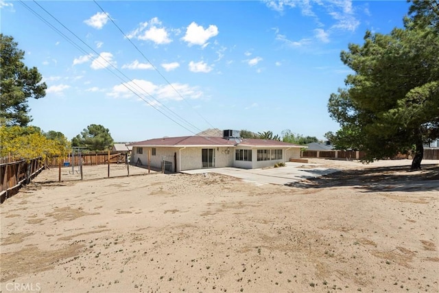 rear view of house with playground community, a patio area, and a fenced backyard