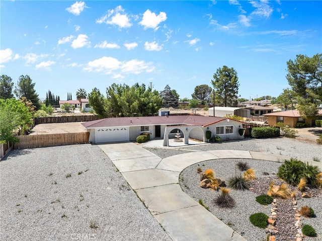 mediterranean / spanish house with an attached garage, driveway, and fence private yard