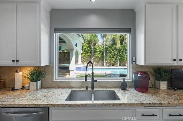 13656 Dronfield Ave, Sylmar, CA 91342 - kitchen featuring tasteful backsplash, stainless steel dishwasher, light stone countertops, a sink, and white cabinets