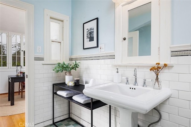 bathroom with a sink and tile walls
