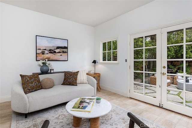 living room with tile patterned floors, baseboards, and french doors