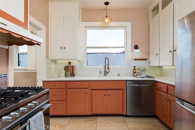 kitchen with white cabinets, pendant lighting, a sink, and appliances with stainless steel finishes