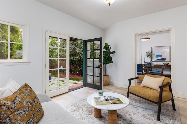 doorway to outside with lofted ceiling, baseboards, and light tile patterned floors