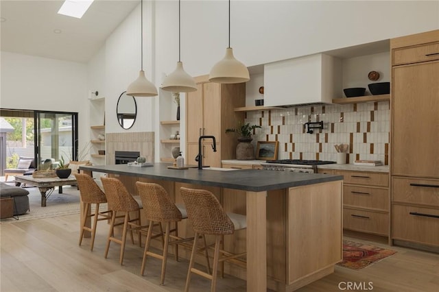 459 E 18th St, Costa Mesa, CA 92627 - kitchen featuring open shelves, decorative backsplash, light wood-type flooring, open floor plan, and dark countertops