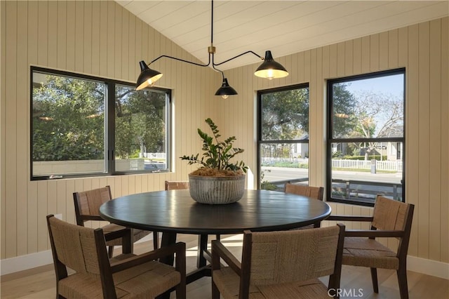 459 E 18th St, Costa Mesa, CA 92627 - dining space with light wood finished floors, vaulted ceiling, and wood walls