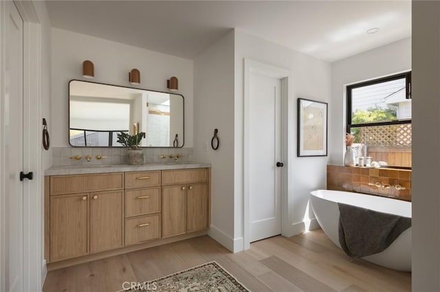 459 E 18th St, Costa Mesa, CA 92627 - bathroom with backsplash, wood finished floors, a freestanding tub, and double vanity