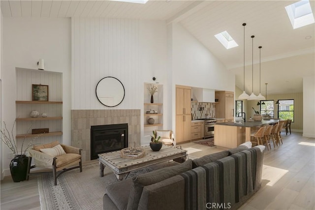 459 E 18th St, Costa Mesa, CA 92627 - living area featuring a skylight, high vaulted ceiling, light wood finished floors, a fireplace, and beamed ceiling