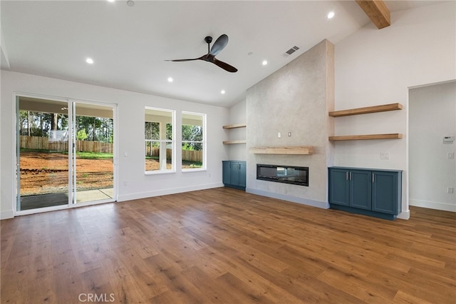 unfurnished living room with a large fireplace, visible vents, ceiling fan, baseboards, and high vaulted ceiling