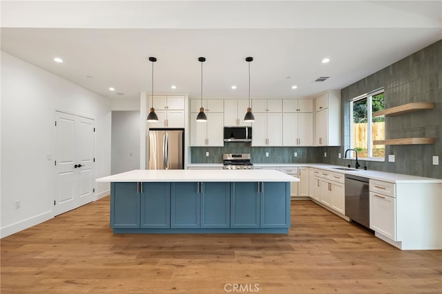 kitchen featuring light wood finished floors, a sink, visible vents, white cabinets, and appliances with stainless steel finishes