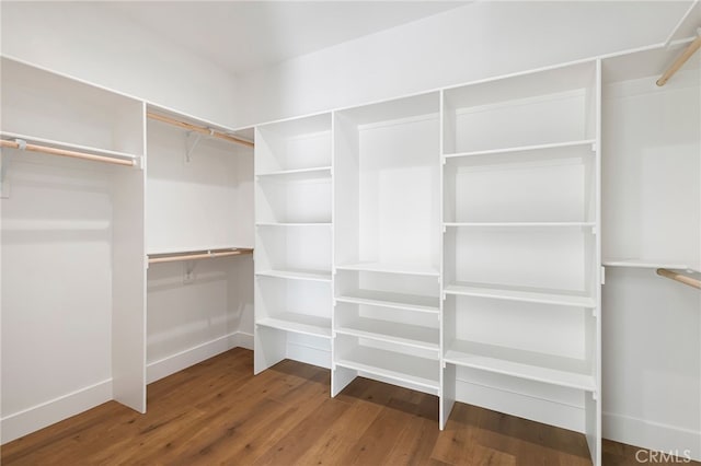 walk in closet with wood finished floors