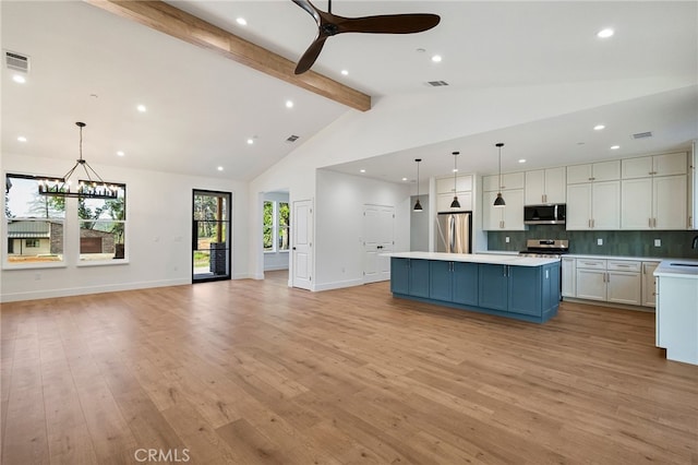kitchen featuring beamed ceiling, a center island, white cabinetry, light countertops, and appliances with stainless steel finishes