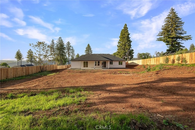 rear view of house featuring fence