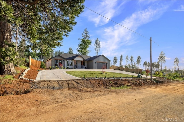 ranch-style home with a front lawn, an attached garage, curved driveway, and fence