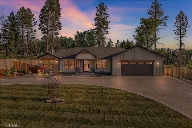 ranch-style home featuring fence, a yard, concrete driveway, and an attached garage