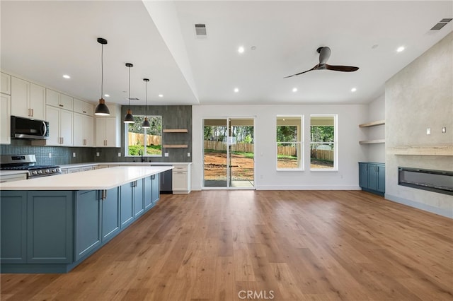 kitchen with ceiling fan, open shelves, visible vents, light countertops, and appliances with stainless steel finishes