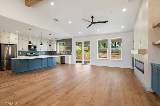 kitchen featuring blue cabinetry, stainless steel appliances, recessed lighting, and vaulted ceiling