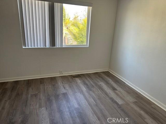 unfurnished room featuring baseboards and wood finished floors