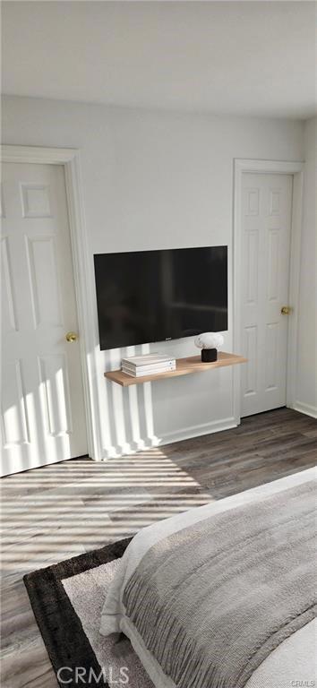 bedroom featuring wood finished floors and baseboards