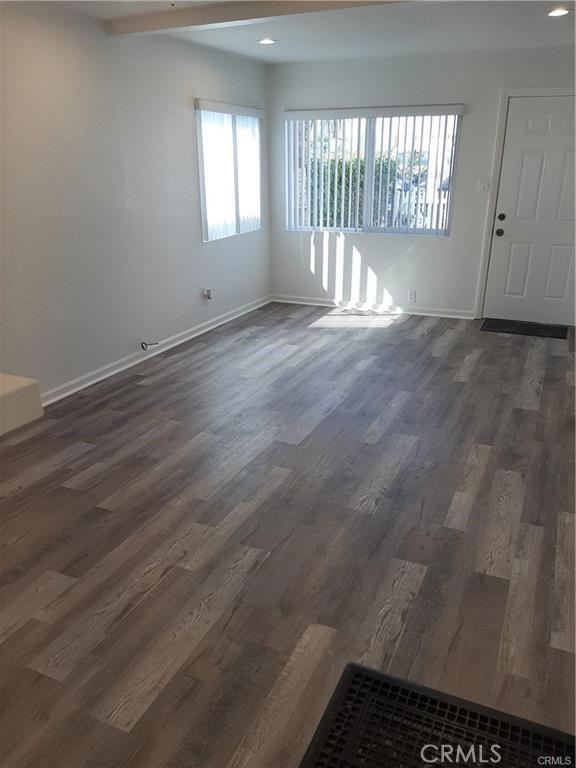 empty room with recessed lighting, dark wood finished floors, and baseboards