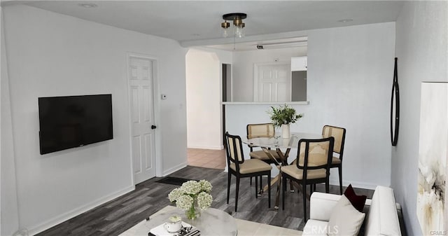 dining space with dark wood-type flooring and baseboards