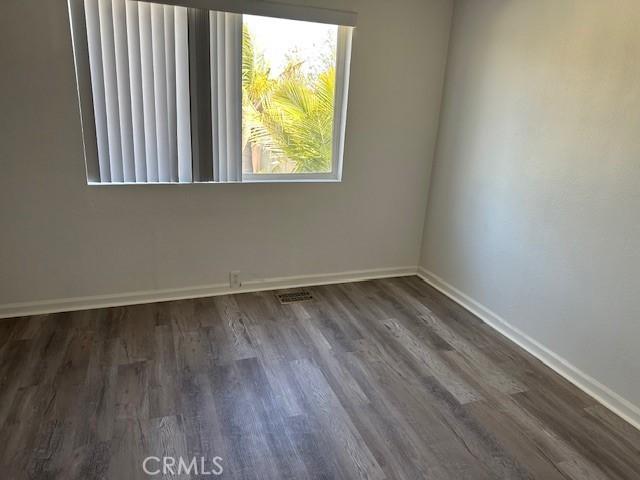 empty room with wood finished floors and baseboards