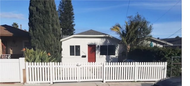 bungalow with stucco siding and a fenced front yard