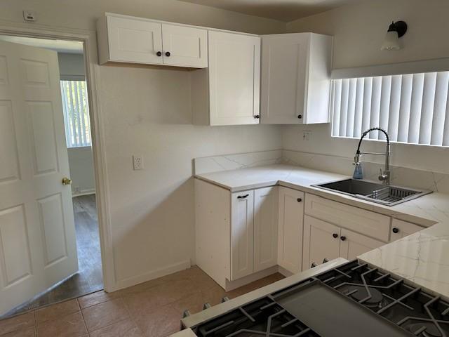 kitchen featuring a sink, white cabinets, and plenty of natural light