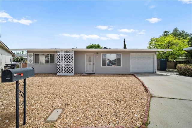 single story home featuring concrete driveway, stucco siding, and a garage