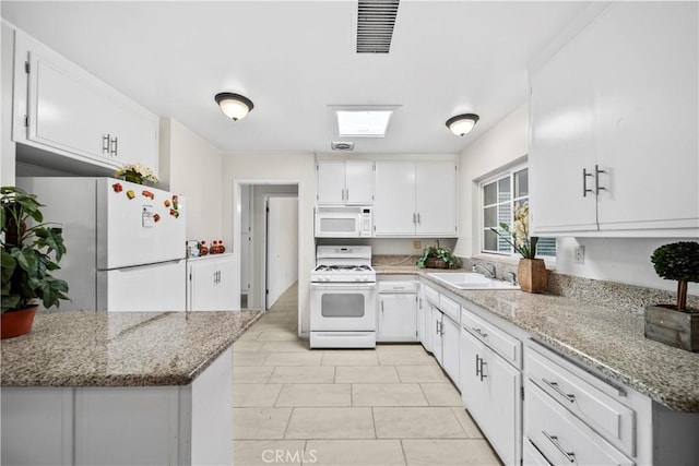 kitchen with white cabinets, a sink, visible vents, white appliances, and light stone countertops
