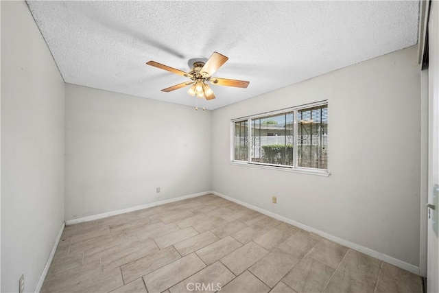 spare room with a textured ceiling, baseboards, and ceiling fan