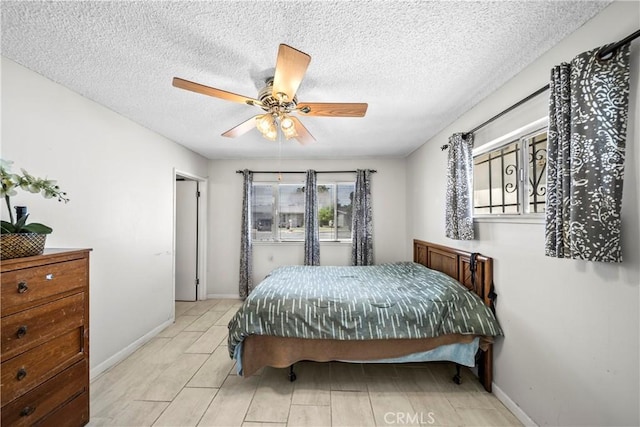 bedroom featuring baseboards, a ceiling fan, and a textured ceiling