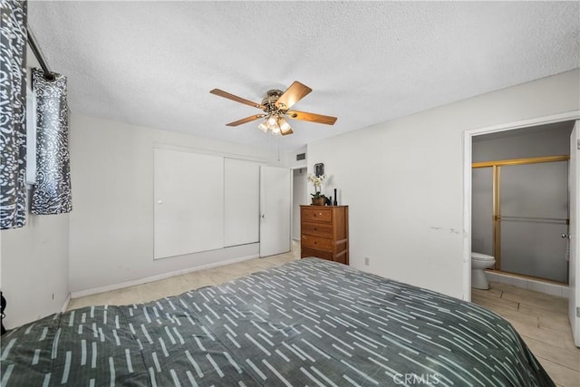 unfurnished bedroom featuring ensuite bath, a textured ceiling, a closet, and ceiling fan