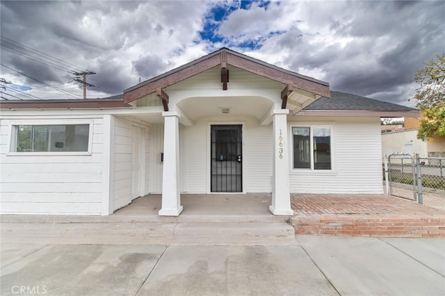 view of front of house featuring covered porch and fence