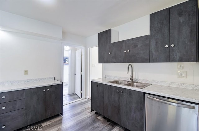 kitchen featuring a sink, dishwasher, dark cabinetry, and dark wood finished floors