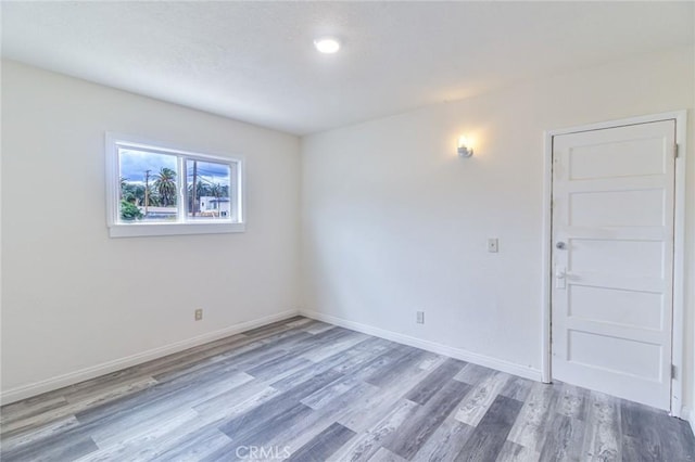 empty room featuring wood finished floors and baseboards