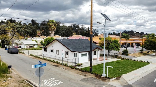 view of front of property featuring a front lawn and fence