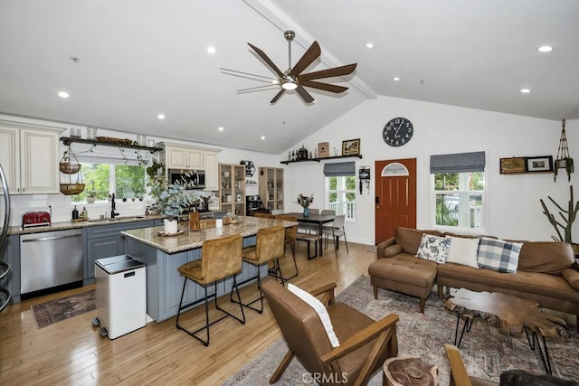 living area featuring recessed lighting, a ceiling fan, beamed ceiling, light wood-style flooring, and high vaulted ceiling
