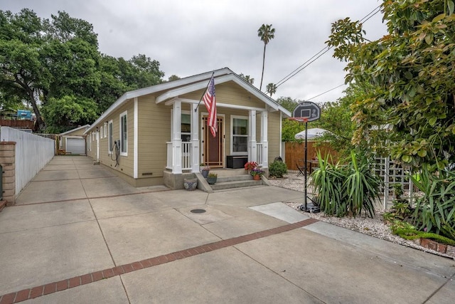 shotgun-style home with fence, an outbuilding, and a detached garage