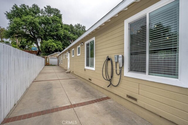 view of home's exterior with fence, crawl space, and an outbuilding