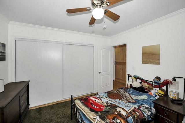 bedroom with dark colored carpet, a closet, crown molding, and a ceiling fan