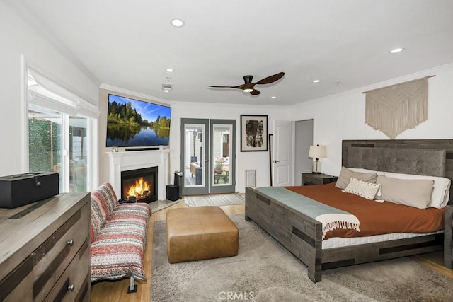 bedroom featuring a fireplace with flush hearth, light wood-type flooring, ornamental molding, and recessed lighting
