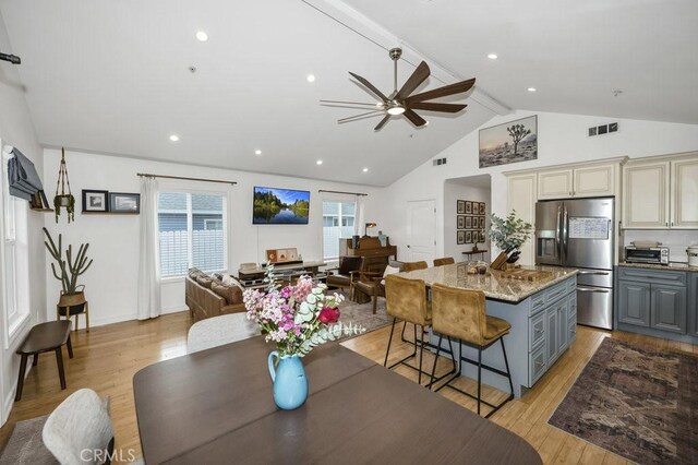 kitchen featuring visible vents, a ceiling fan, gray cabinetry, stainless steel refrigerator with ice dispenser, and open floor plan