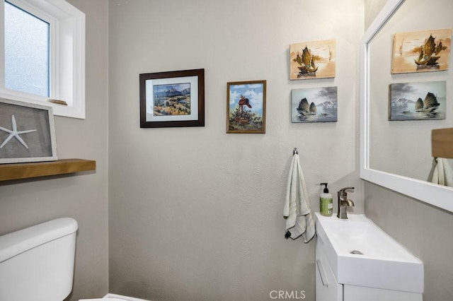 half bath featuring toilet and vanity