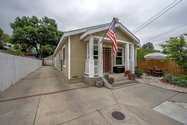 shotgun-style home with fence and a porch